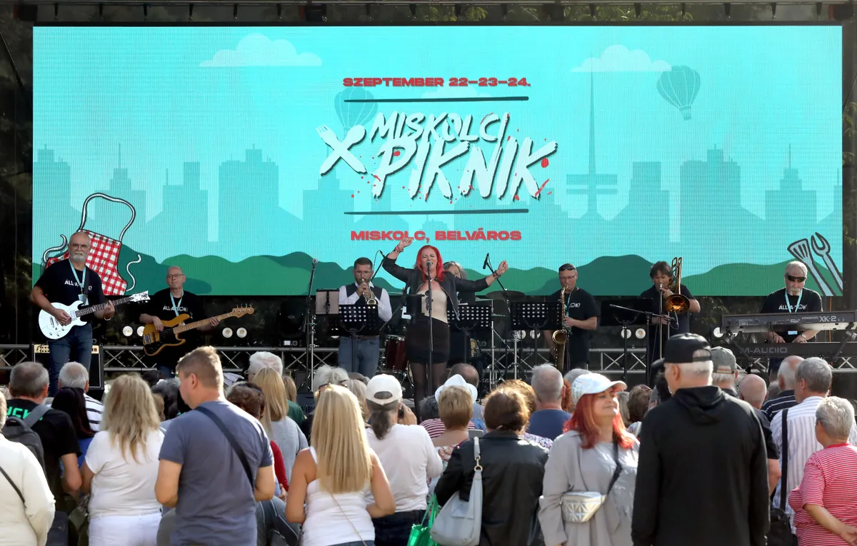 A miskolci piknik színpadán zenél a zenekar a közönség állva hallgatja az ingyenes programon