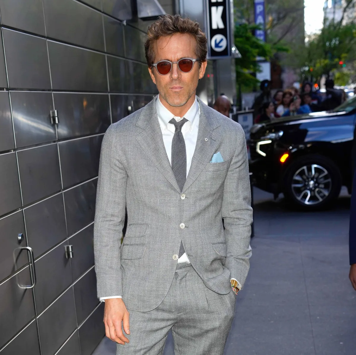 Ryan Reynolds szürke öltönyben és napszemüvegben az utcán