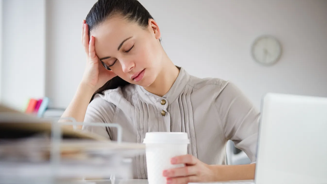 Fiatal nő, aki a munkában fáradtsággal küzd