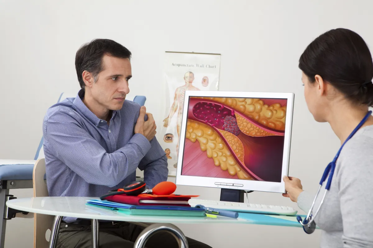 Érelmeszesedést a betegnek illusztráción mutató doktornő a rendelőben