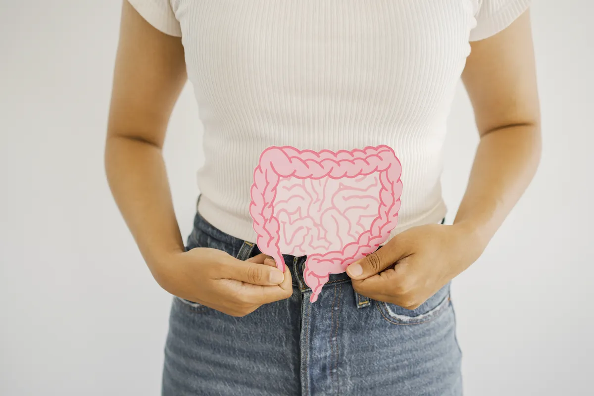 Bél modellen bélrákot demonstráló nő