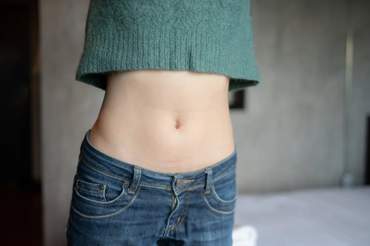Close up of woman with slim waist. Conceptual shot of woman showing her diet results.