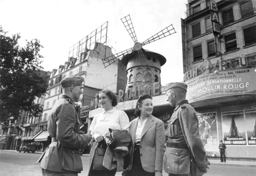1940 júniusa: két német katona beszélget a Moulin Rouge előtt Párizs náci megszállásának idején.