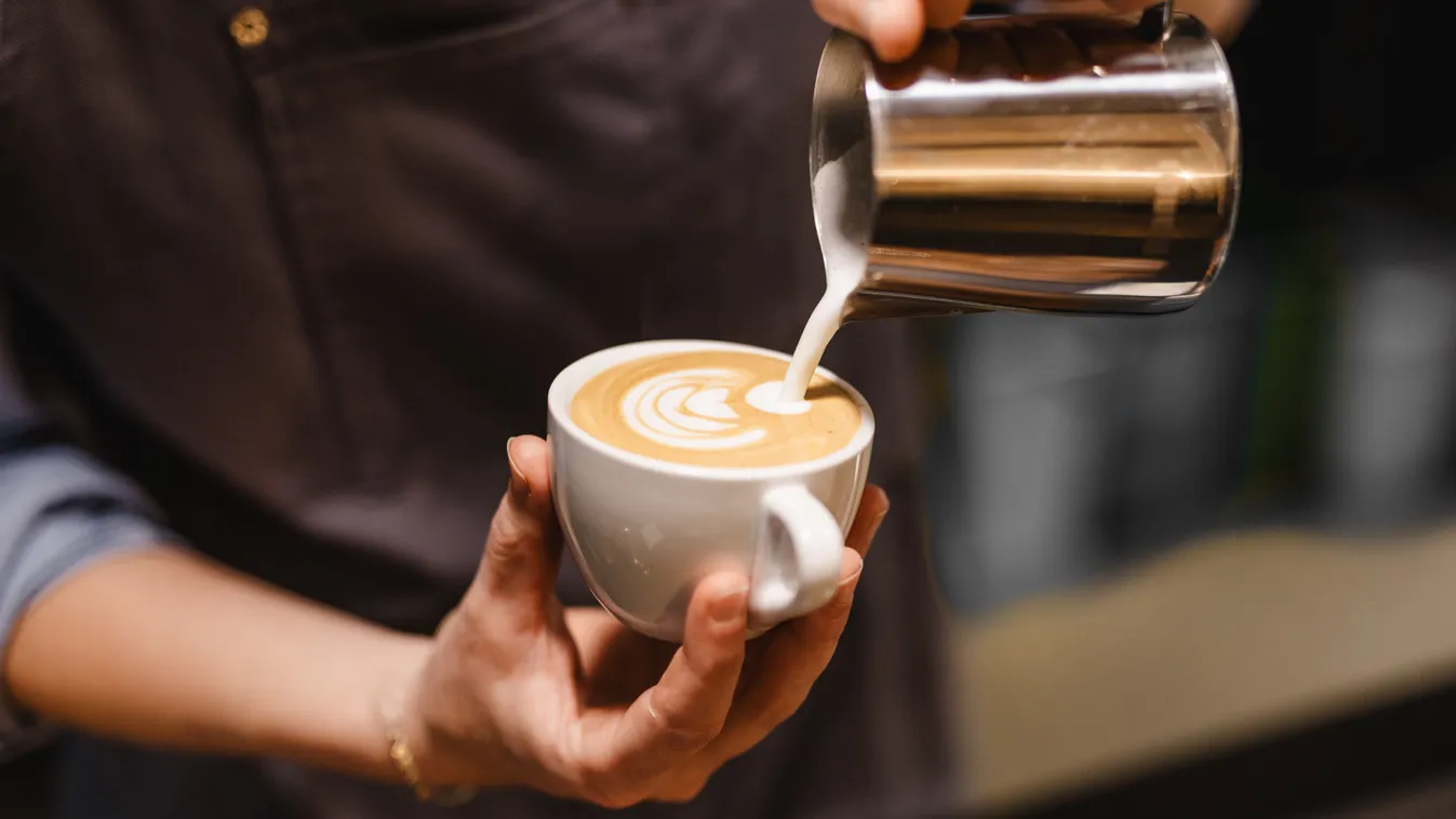 Egy férfi lattét készít magának, aki személyiségtesztünk alapján feltehetően extrovertált