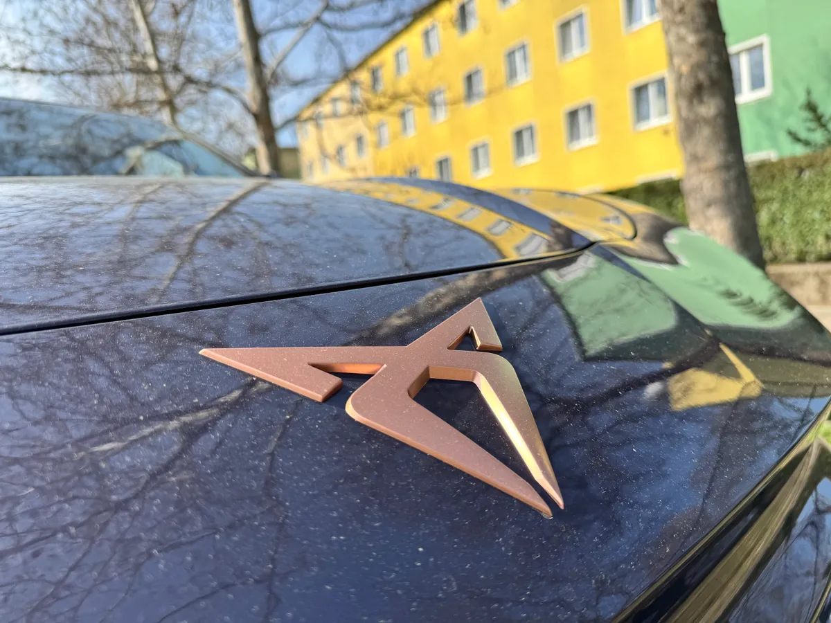 Cupra Terramar, szürke autó áll a parkolóban, épületek a jobb oldalán