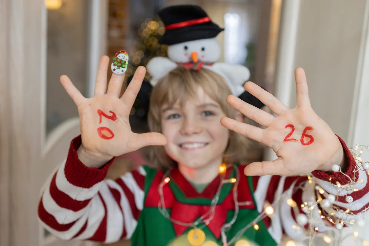 Gyerek családi szilveszteren égősorral a nyakában.