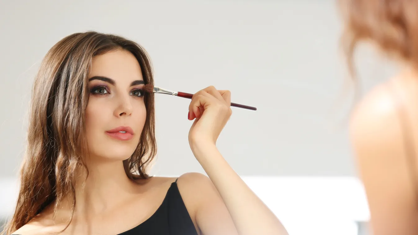 Fiatal lány, aki éjszakai sminket készít magának