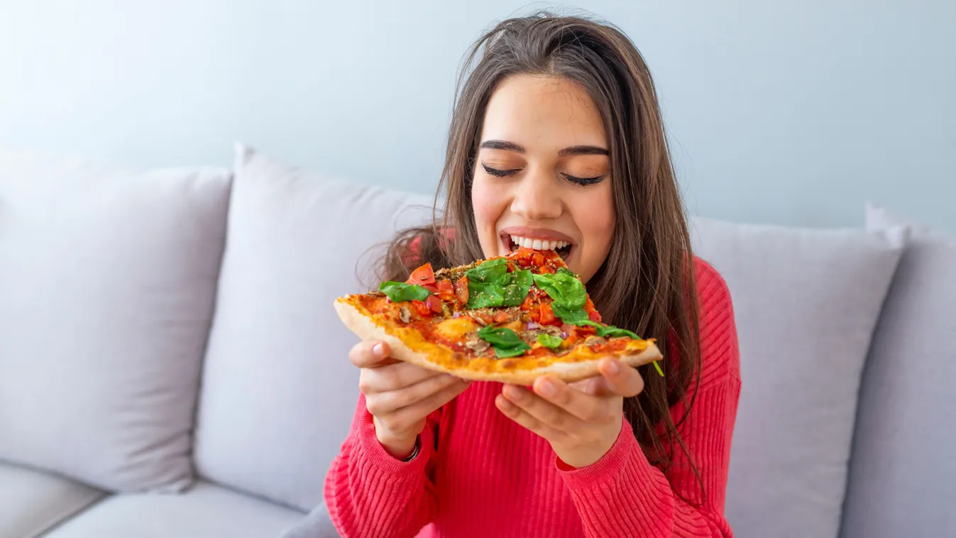 Fiatal lány, aki pizzát eszik, hogy ne érje utol az influenza