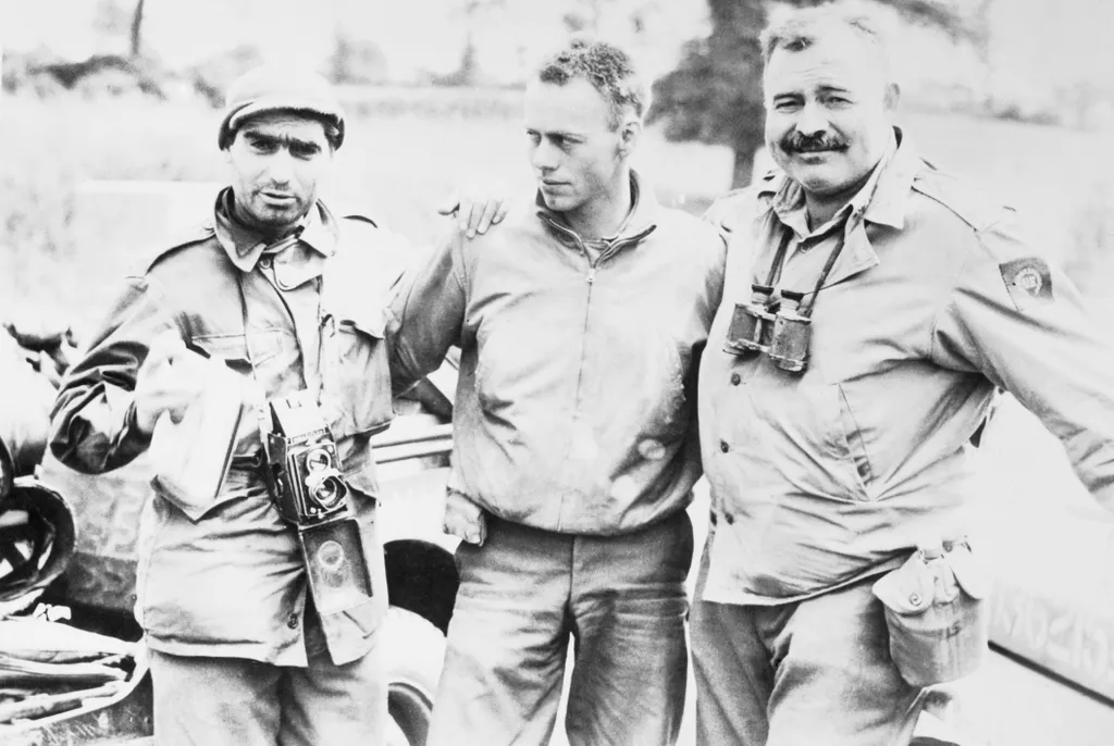 Robert Capa (balra), a Life magazin fotósa, és Ernest Hemingway (jobbra) egy azonosítatlan katonával