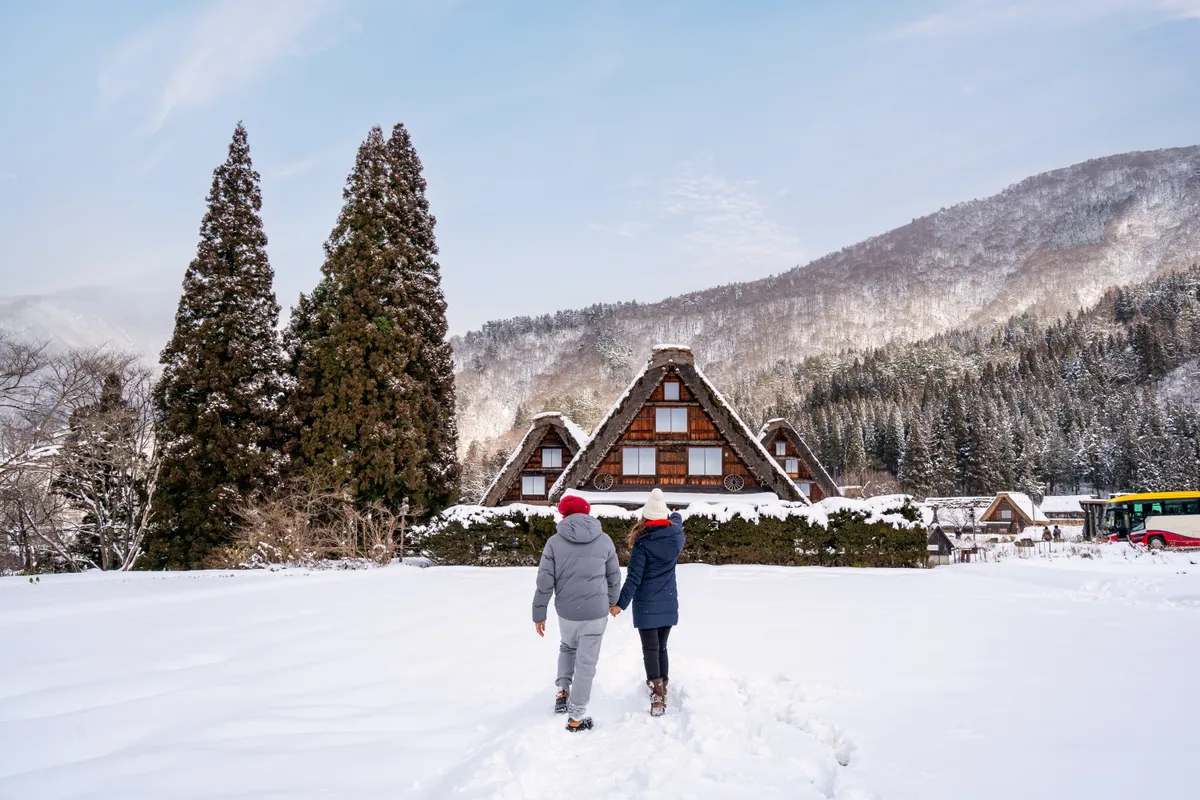 Egy pár Zakopane-ban sétál a hóban egy ház felé.