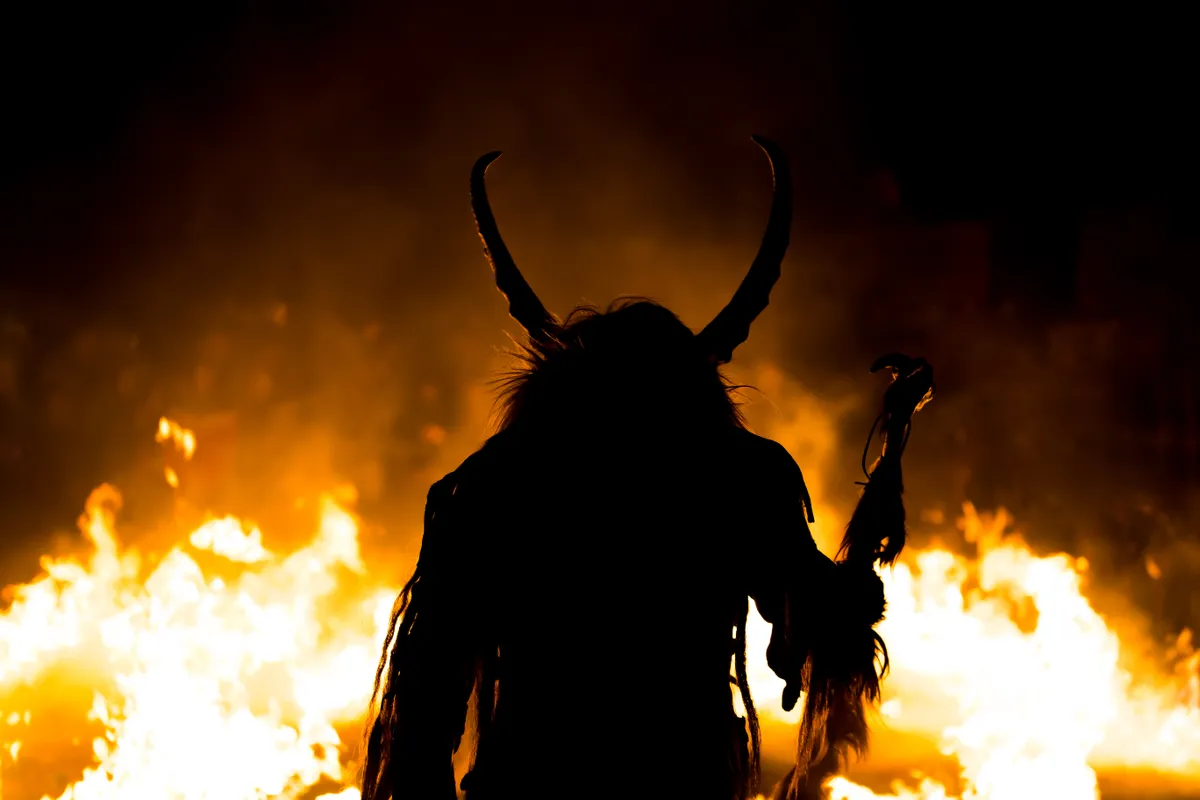Egy Krampuszjelmezes ember Németországban ahol az ünnepi szokás a Krampuszüldözés a Krampusnacht fesztiválon.