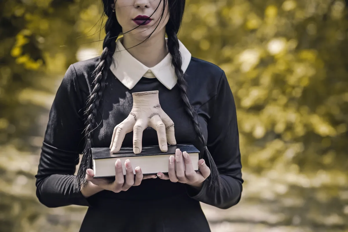 Wednesday egy könyvvel a kezében