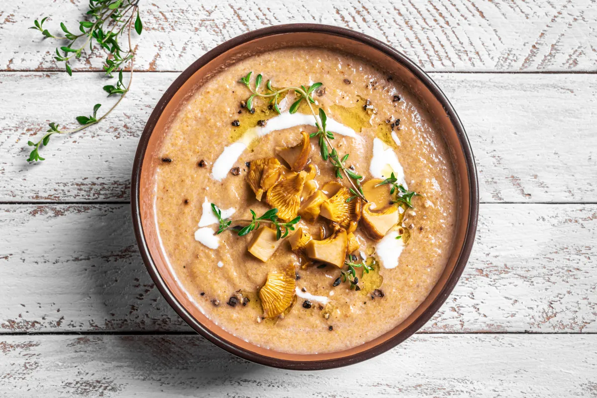 Chanterelle,Mushroom,Soup,With,Thyme,And,Fresh,Mushrooms,On,White