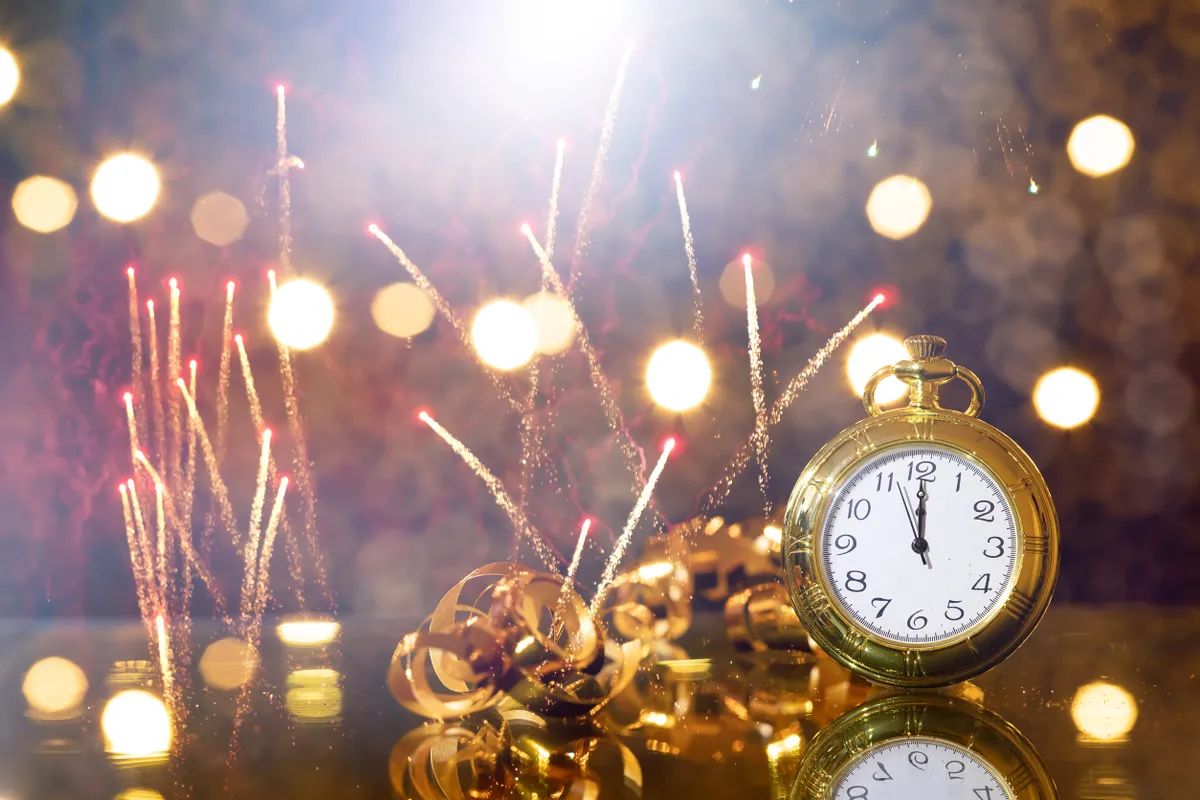 Szilveszteri rituálét szimbolizáló óra tűzijáték és fények