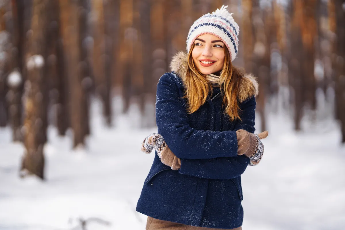 Mosolygó fiatal lány téli öltözködése.