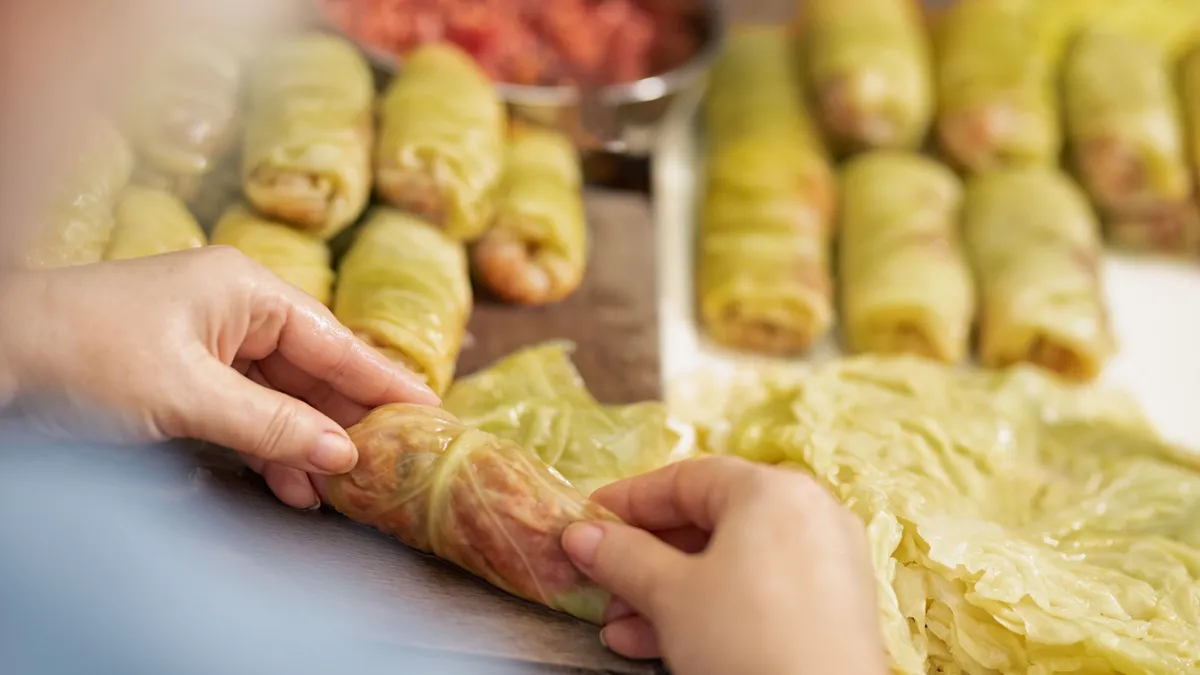 Két női kéz ami diétás töltött káposzta batyukat készít.