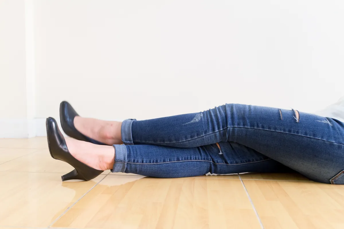 Egy nő a földön fekszik farmerban és magassarkúban a nadrághossz tökéletes nincs öltözködési baki