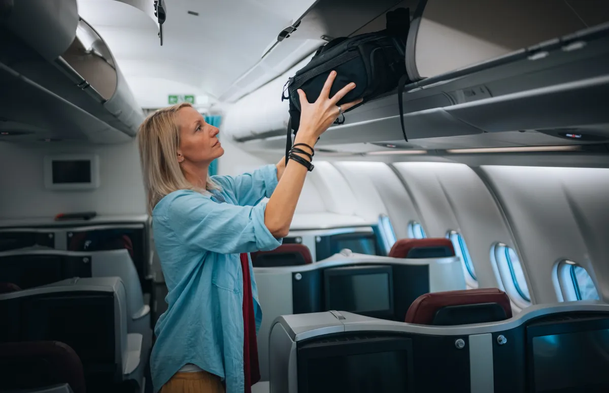 A repülő fedélzetén pakoló nő