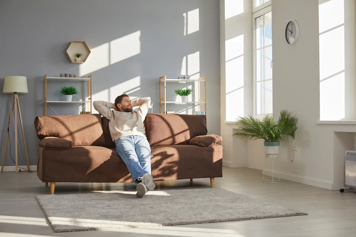Egy férfi a kanapéján élvezi otthona kényelmét