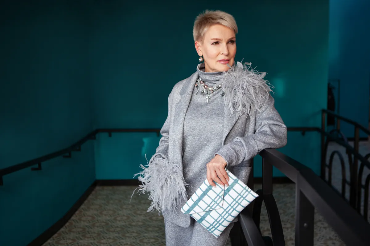 50 feletti hölgy divatos szürke ruhában.