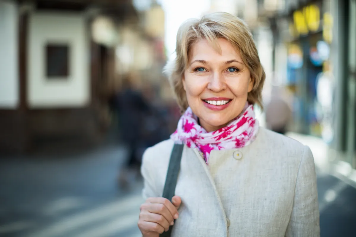 Középkorú nő színes sállal a nyakában