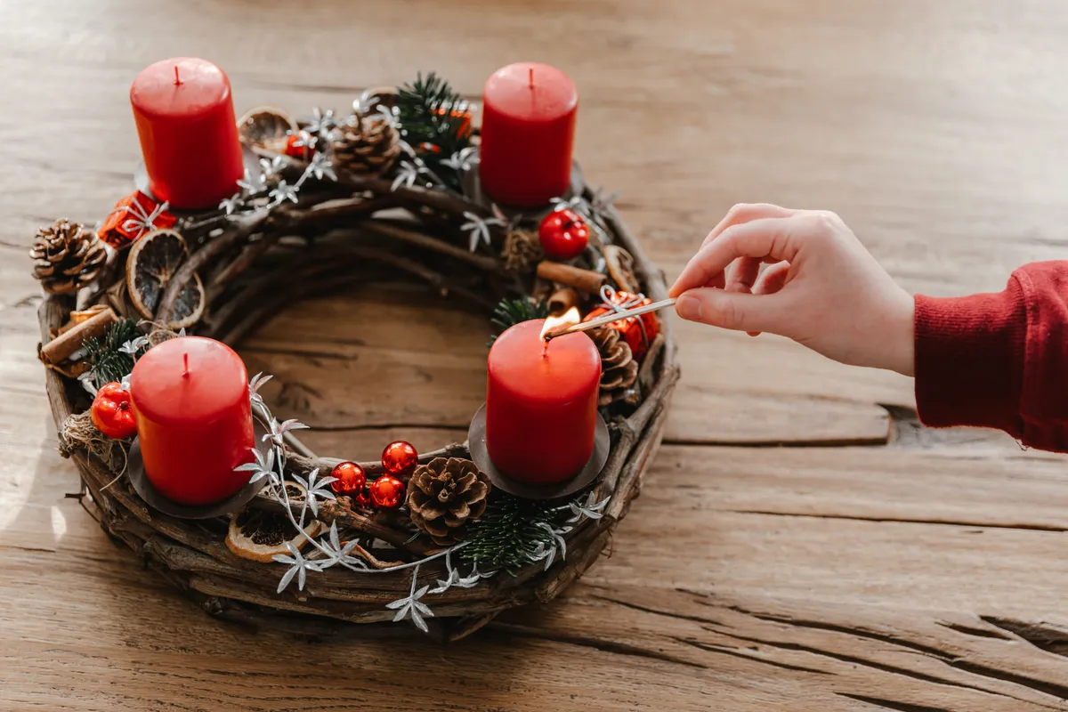 Adventi gyertyagyújtás egy adventi koszorún advent első vasárnapján