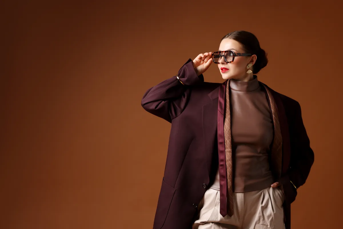 Divatos téli színekbe öltözött nő napszemüvegben.