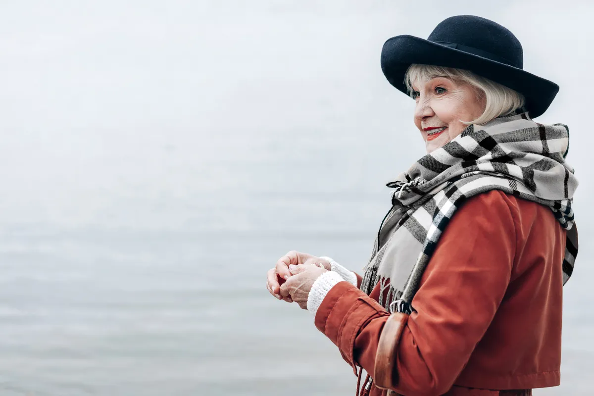 Ötven feletti nő kockás sálban a tengerparton