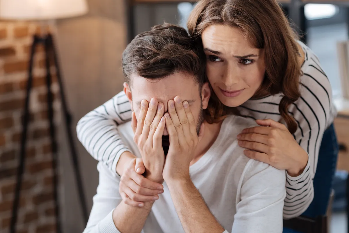 A férfit átöleli a párja