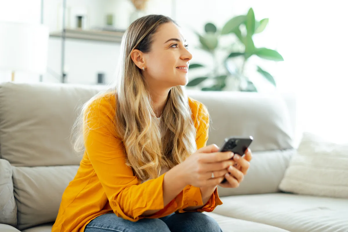 Nő online ügyintézés közben a kanapén