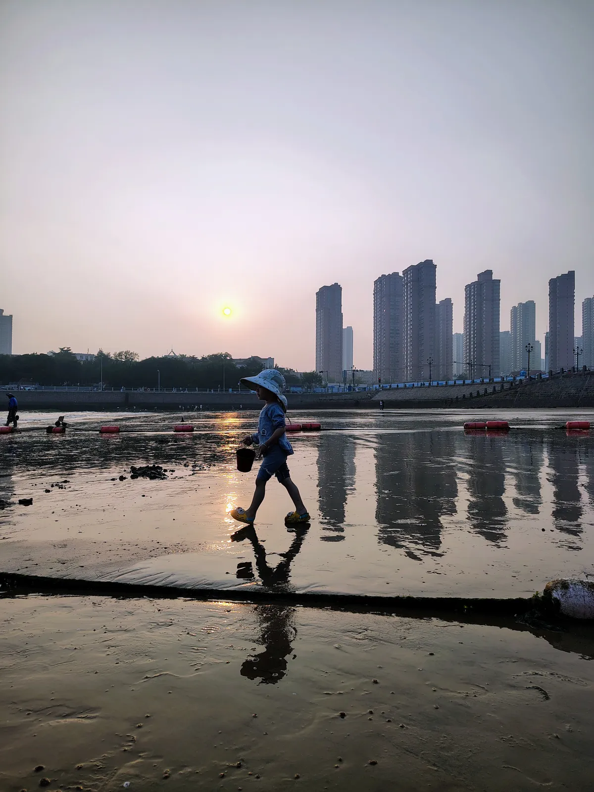 Kína legszebb helyeinek egyike: kislány a Csingtao tengerpartján.