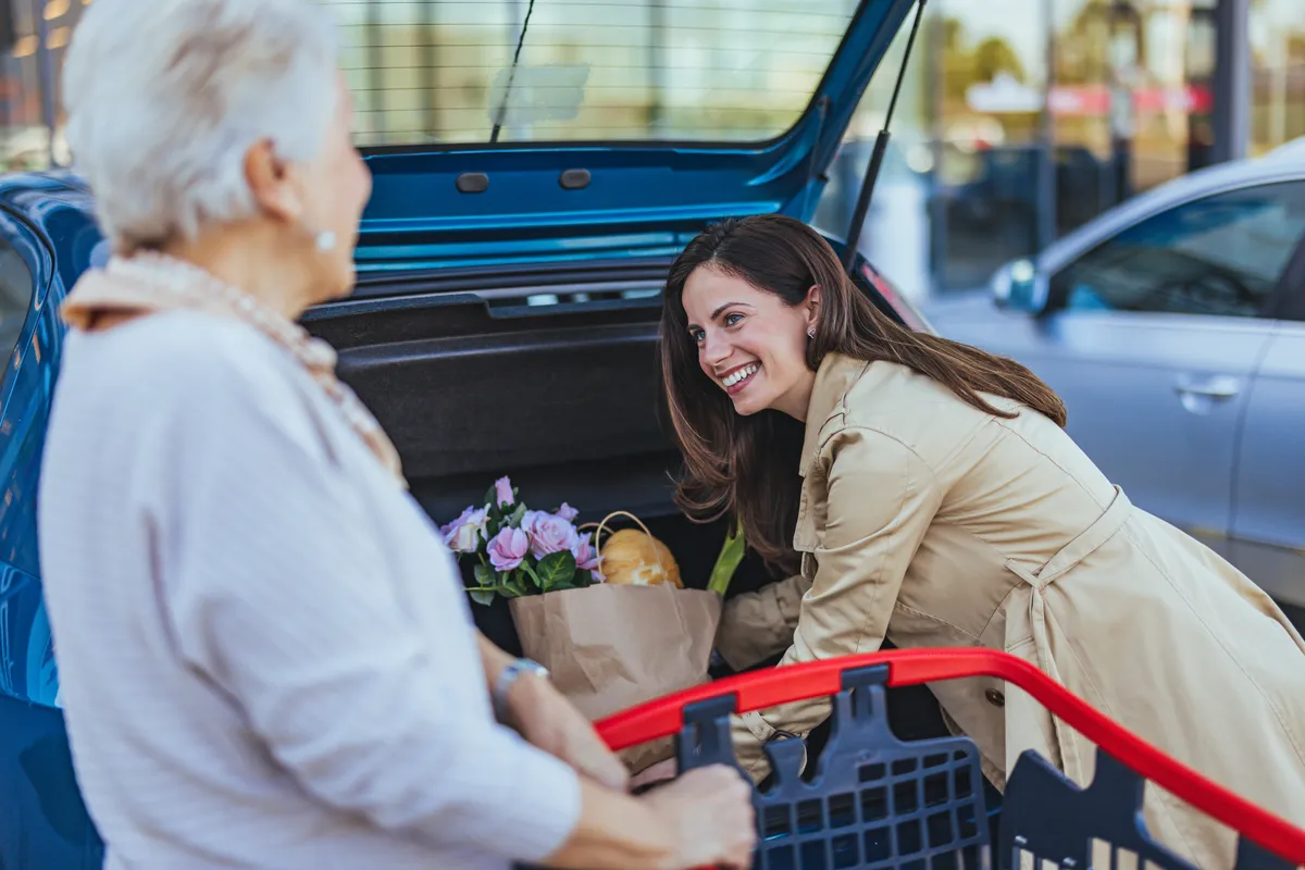 Fiatal nő kedvességből segít egy idős nőnek
