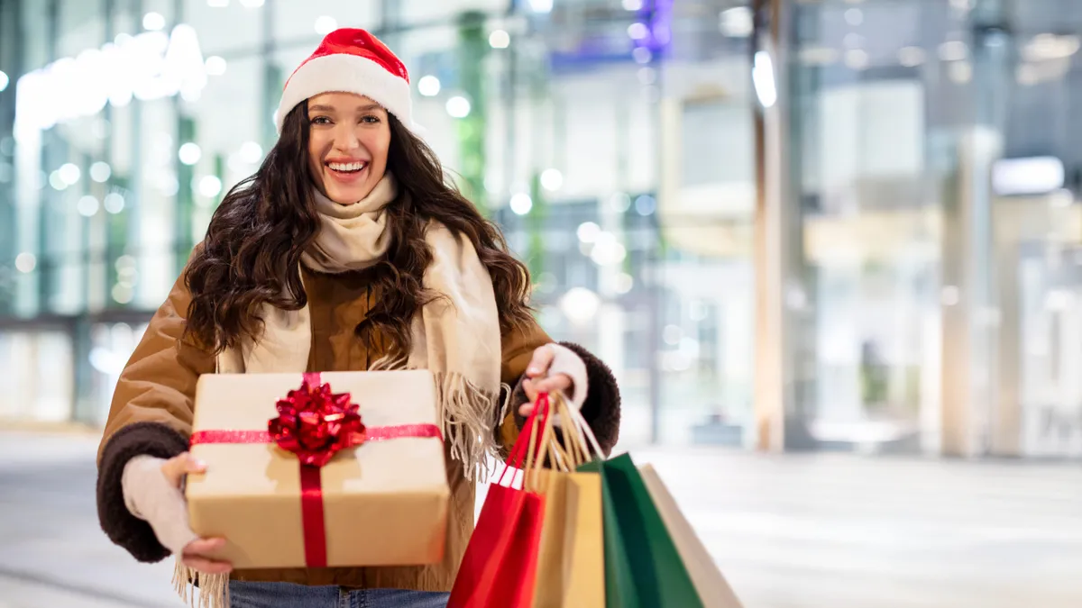 Karácsonyi ajándékbeszerzést tart a fiatal nő.