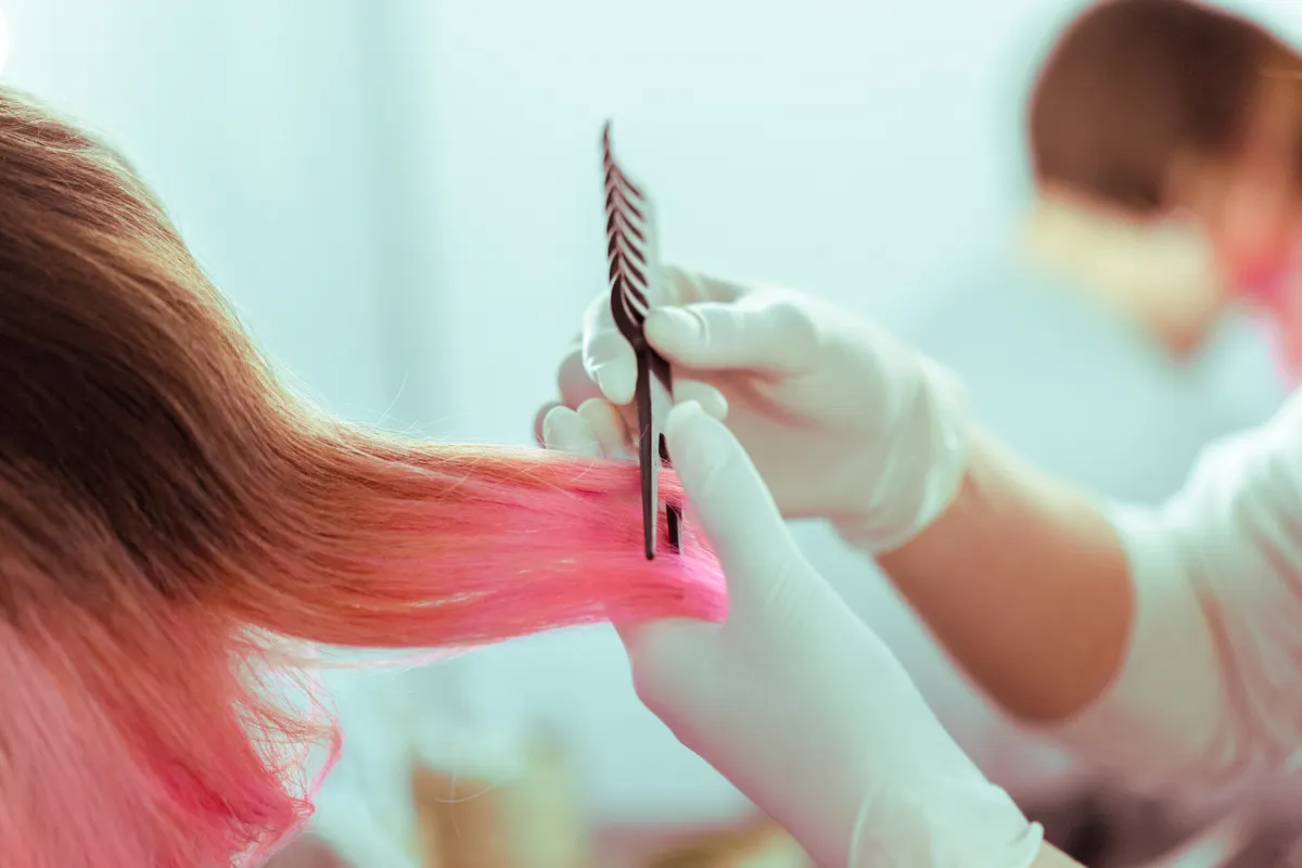 A fodrász épp festett haj ápolását végzi.