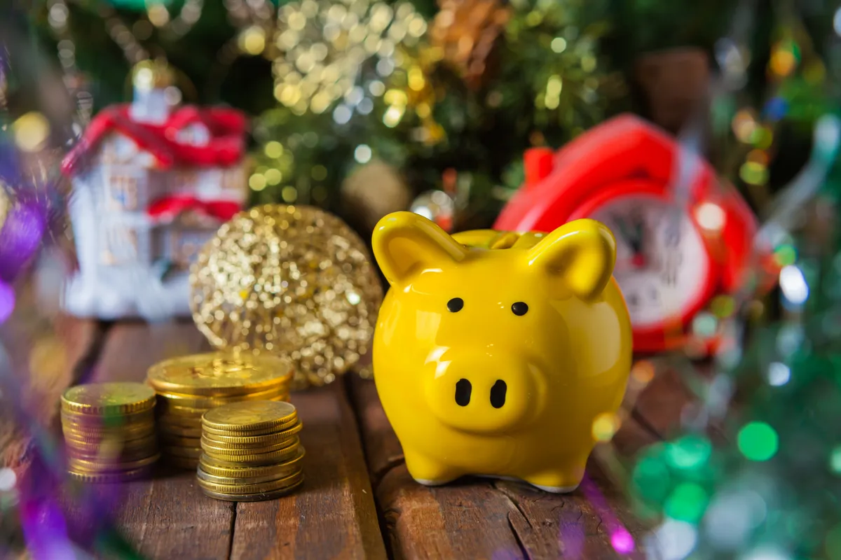 Karácsonyi spórolásból összegyűlt aprópénz egy malacpersely mellett