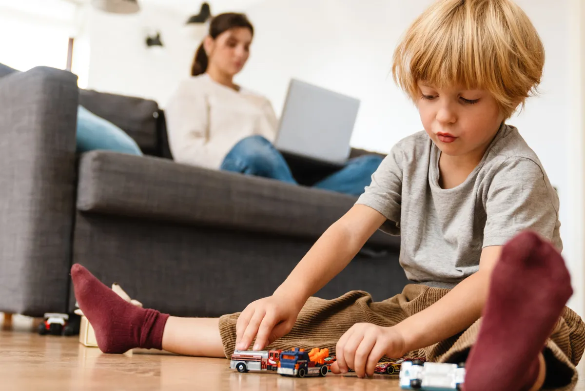 Boy playing on the floor with car toys