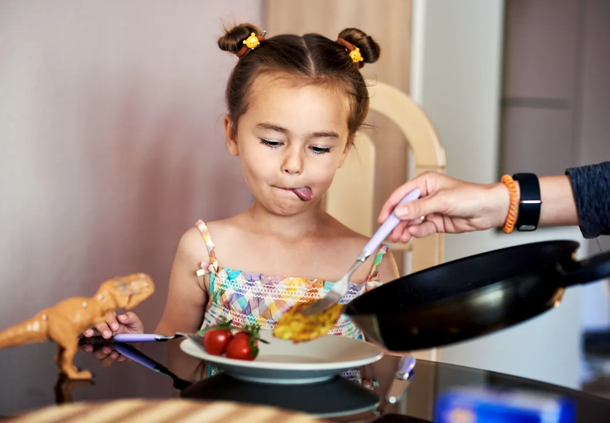 Válogatós gyerek paradicsomot és pirítóst eszik.