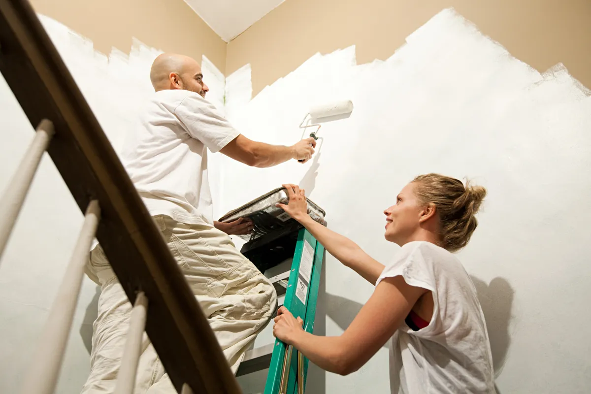Egy pár festi az otthona falait