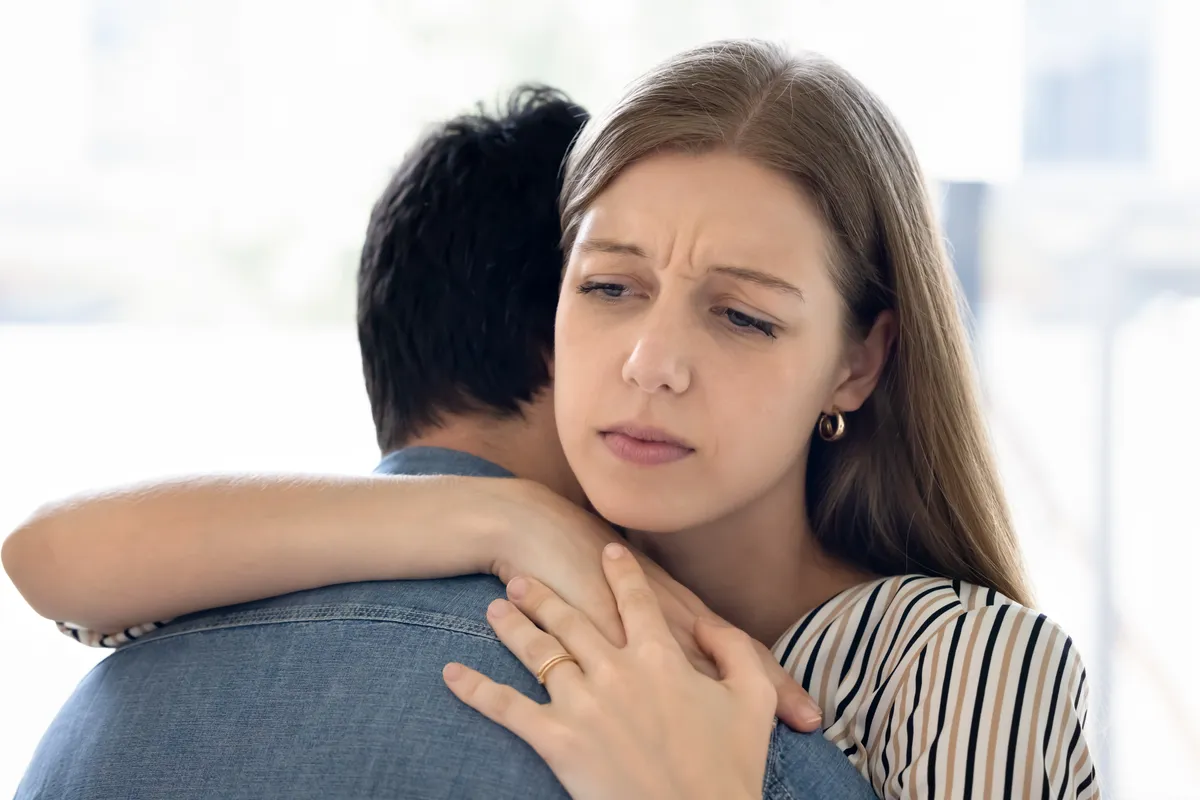 Fiatal ölelkező pár, miután veszekedtek, mert a feleség nem kezdeményezett együttléteket.