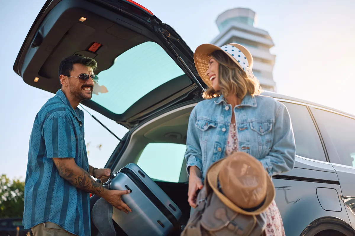 utazási trükk kézipoggyász felcsempészésére, fiatal pár a repülőtéren.