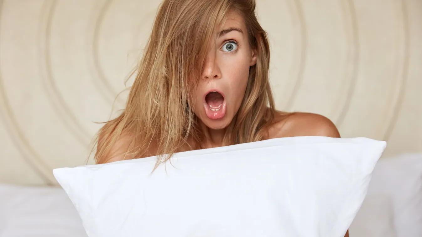 Álmából felriadó nő, akinek álomfejtésre van szüksége.