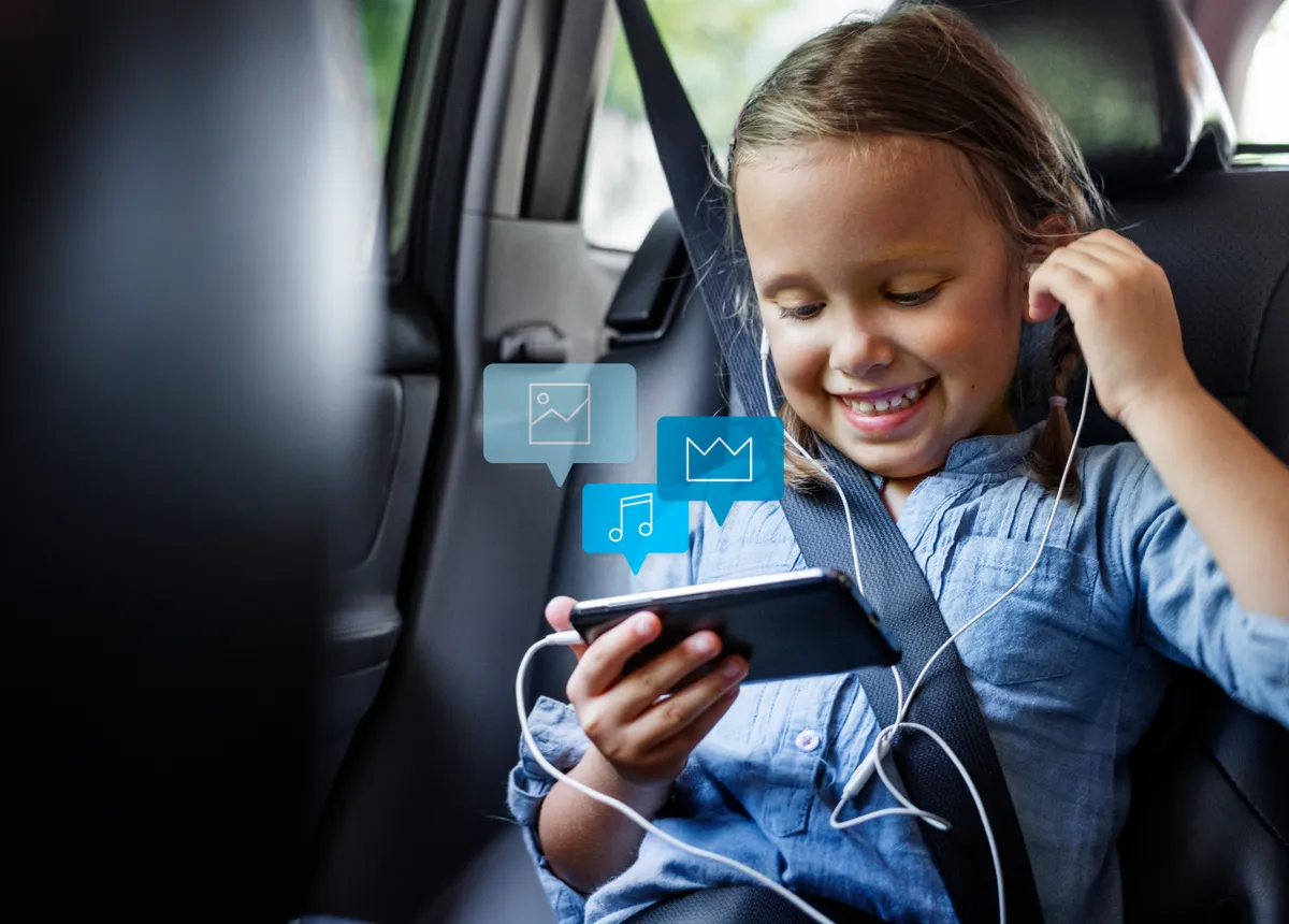 Kislány az autóban nem szenved utazási betegségtől, mert letöltötték a telefonra a megfelelő appot. 