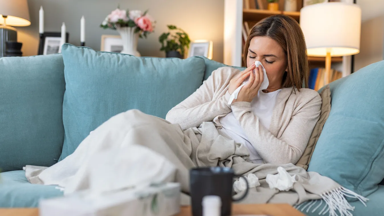 A téli tünetek közé tartozik a nátha is, amivel a képen látható nő is küzd.