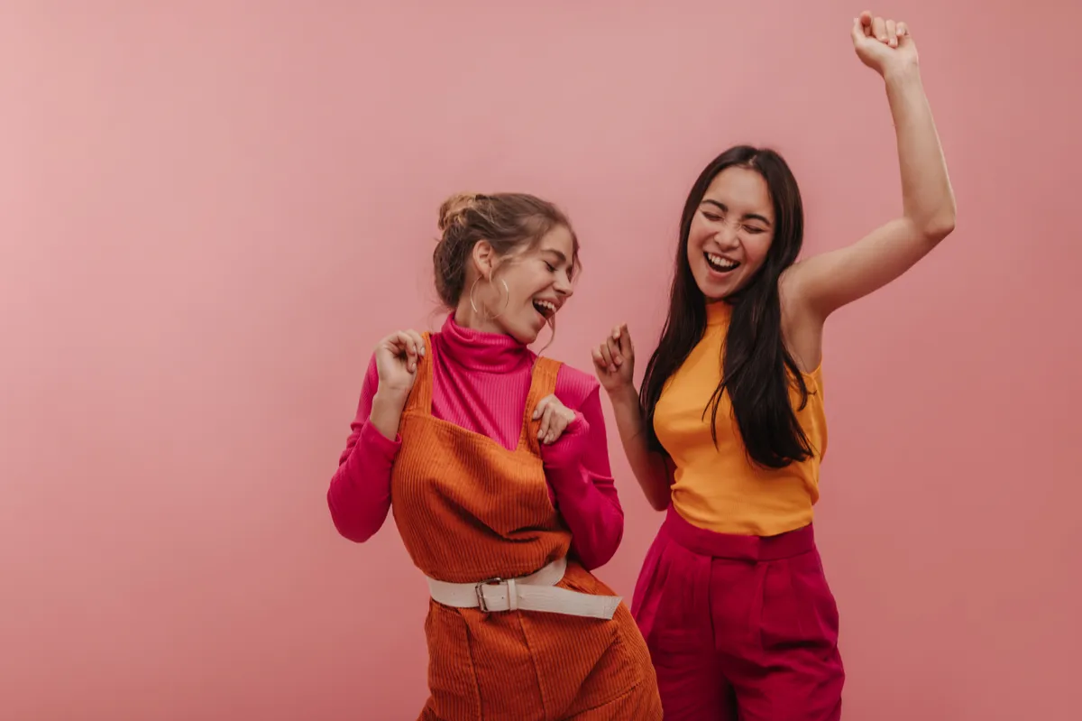 Személyiségtesztben szereplő kép két boldog, táncoló fiatal nőről