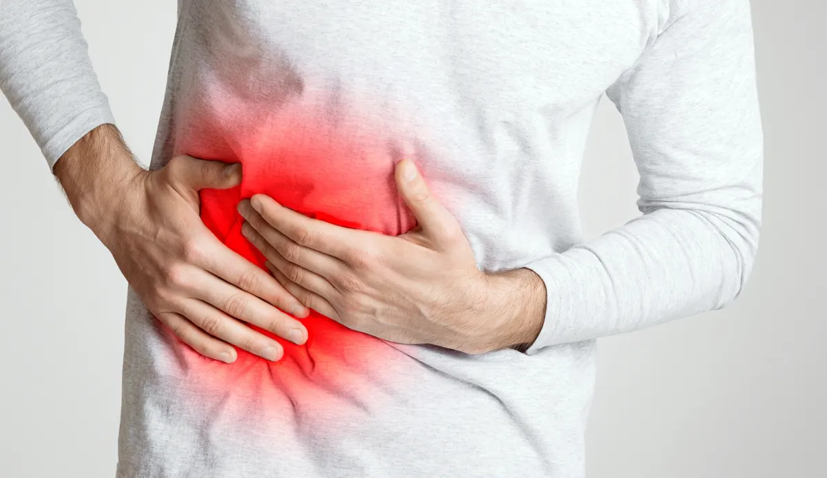 Egy férfi fájlalja a hasát, mert zsírmáj alakult ki nála. 