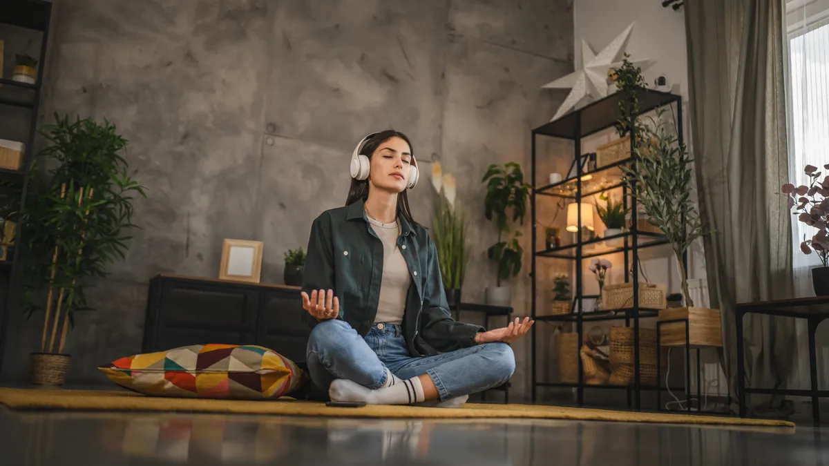 Zenét hallgatva meditáló fiatal nő