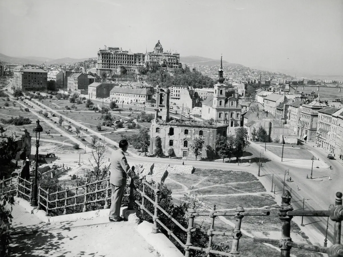 A Tabán 1945-ben a Gellérthegy felől egy nézelődő férfival, háttérben a romos templomok és a romos budai vár.