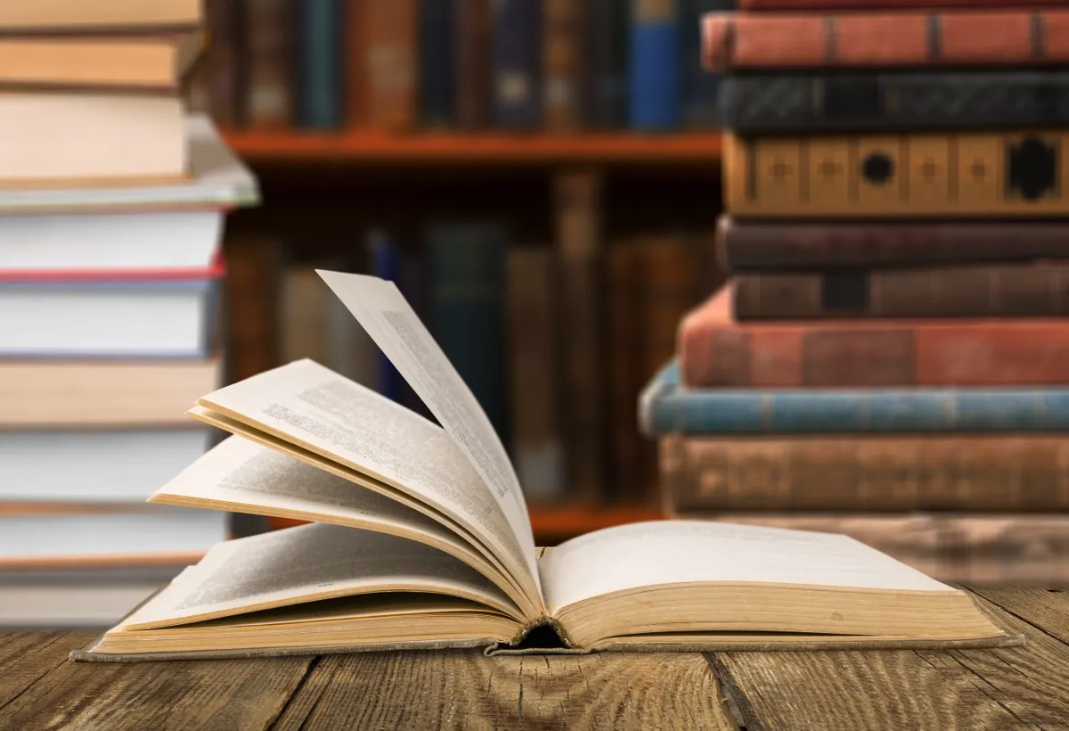 Nyitott könyv az asztalon, töltsd ki a kötelező olvasmányokról szóló kvízünket.