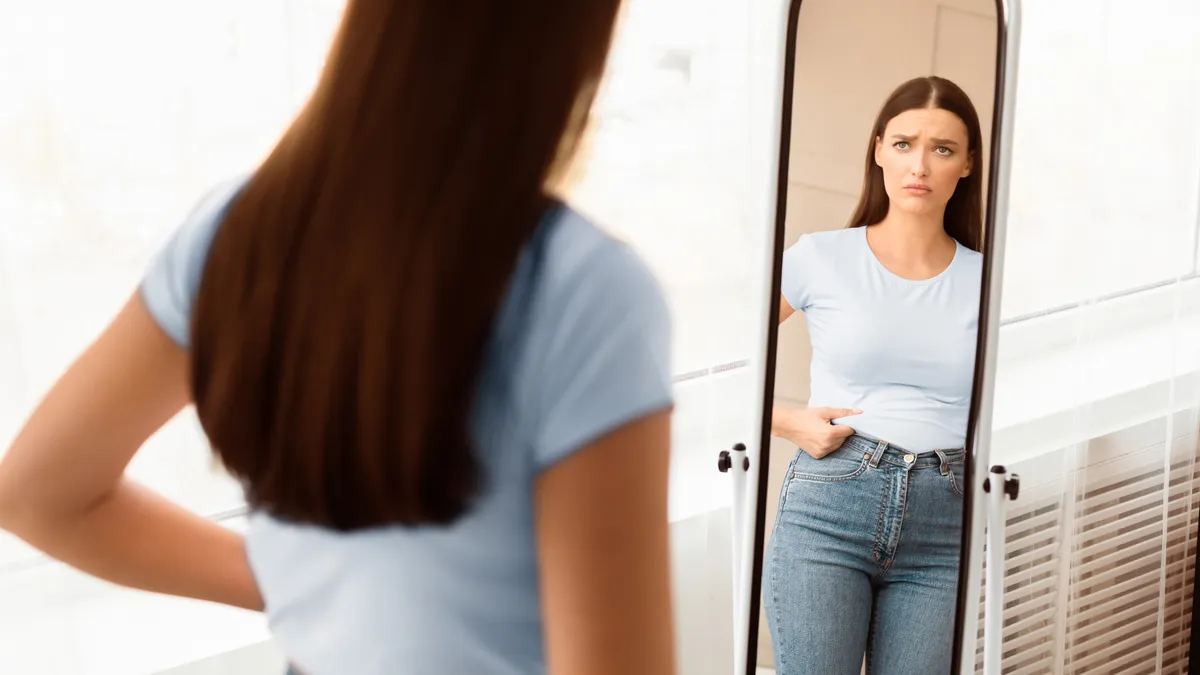 Fogyás hasról a legnehezebb, fiatal nő a tükörben nézi magát