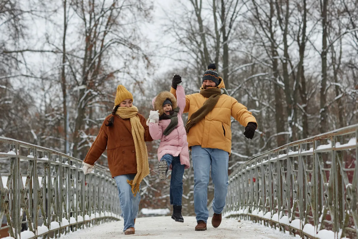 Havas hídon sétáló, boldog család, akiknek ez az ünnepi szokásuk része.